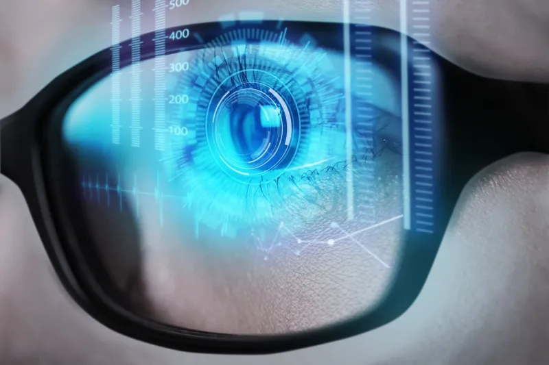 an eye cast in blue light looking through glasses